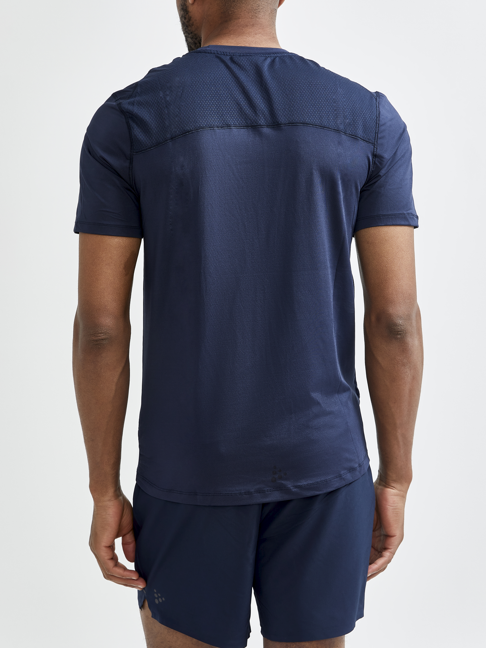 Man models a navy blue athletic t-shirt with breathable mesh paneling on the upper back.