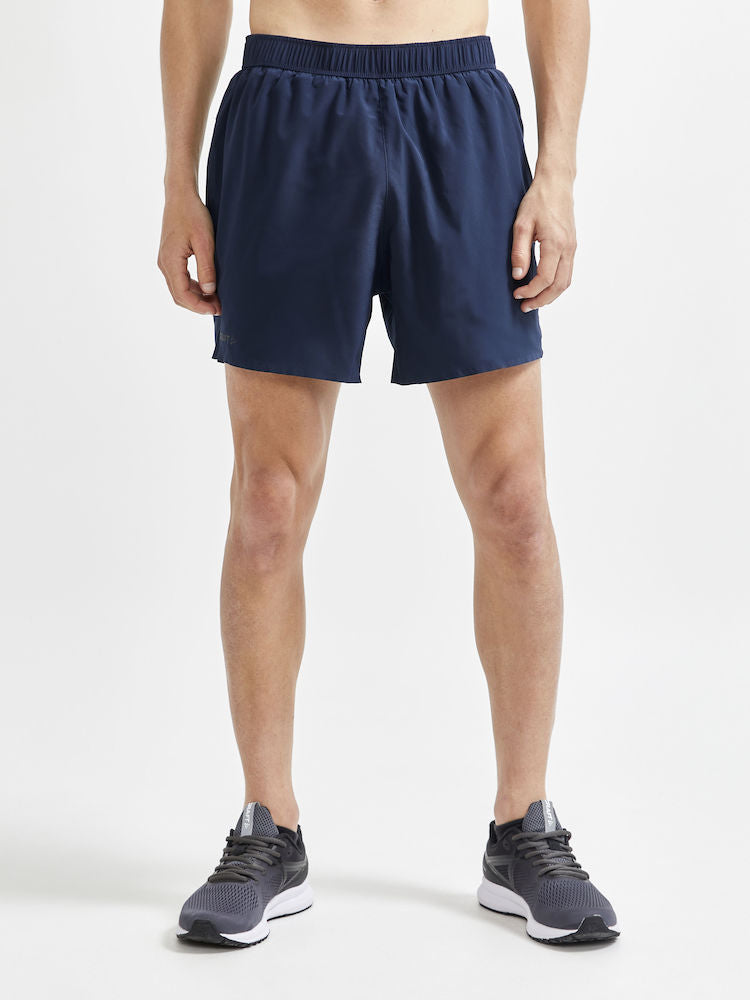 Man models navy blue running shorts with an elastic waistband.