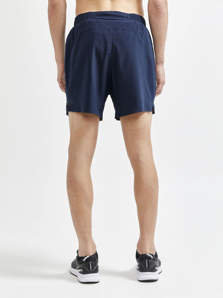 Man models navy blue running shorts from the back.
