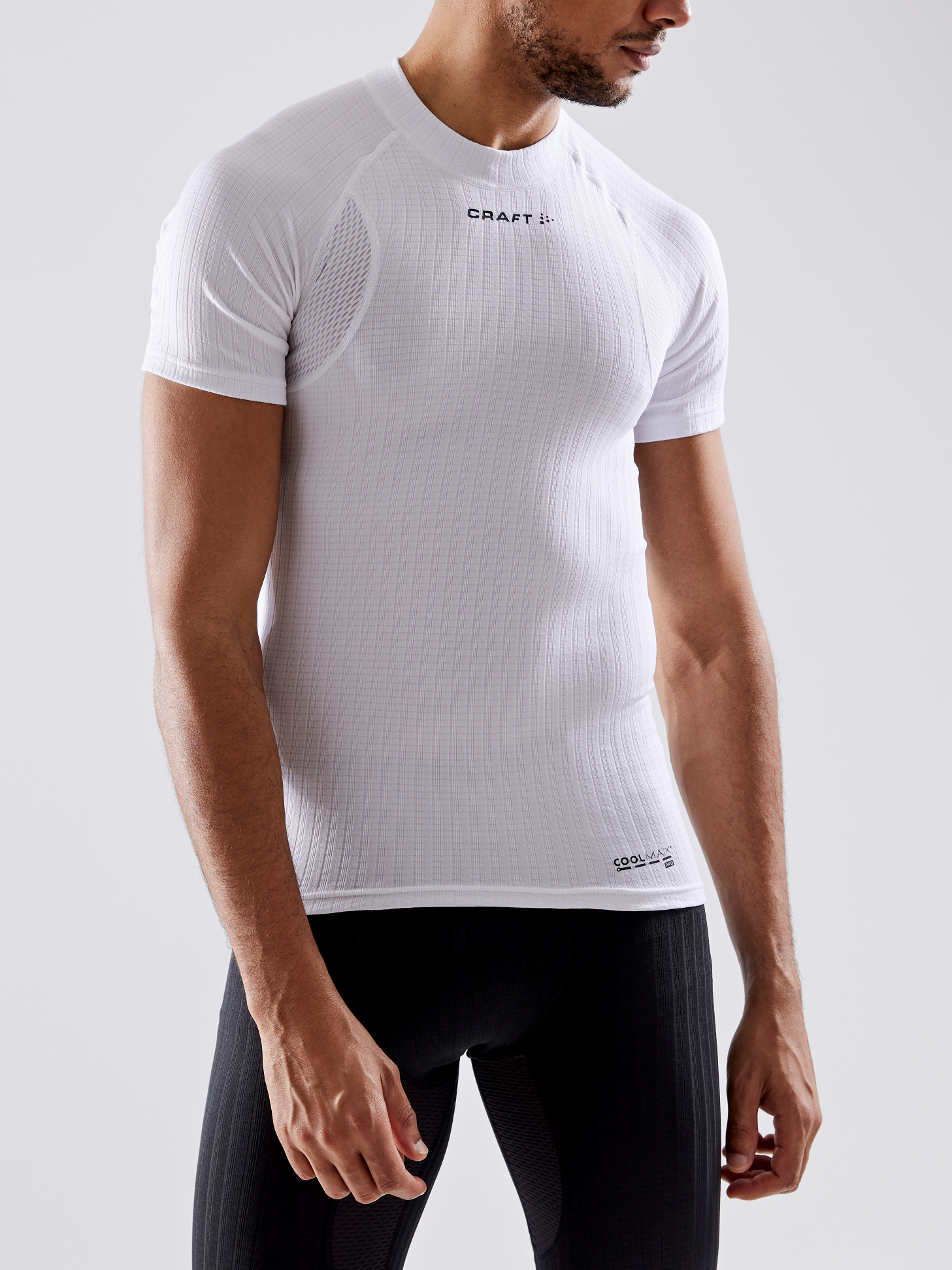 Man models white Craft Sportswear Coolmax short sleeve compression shirt.