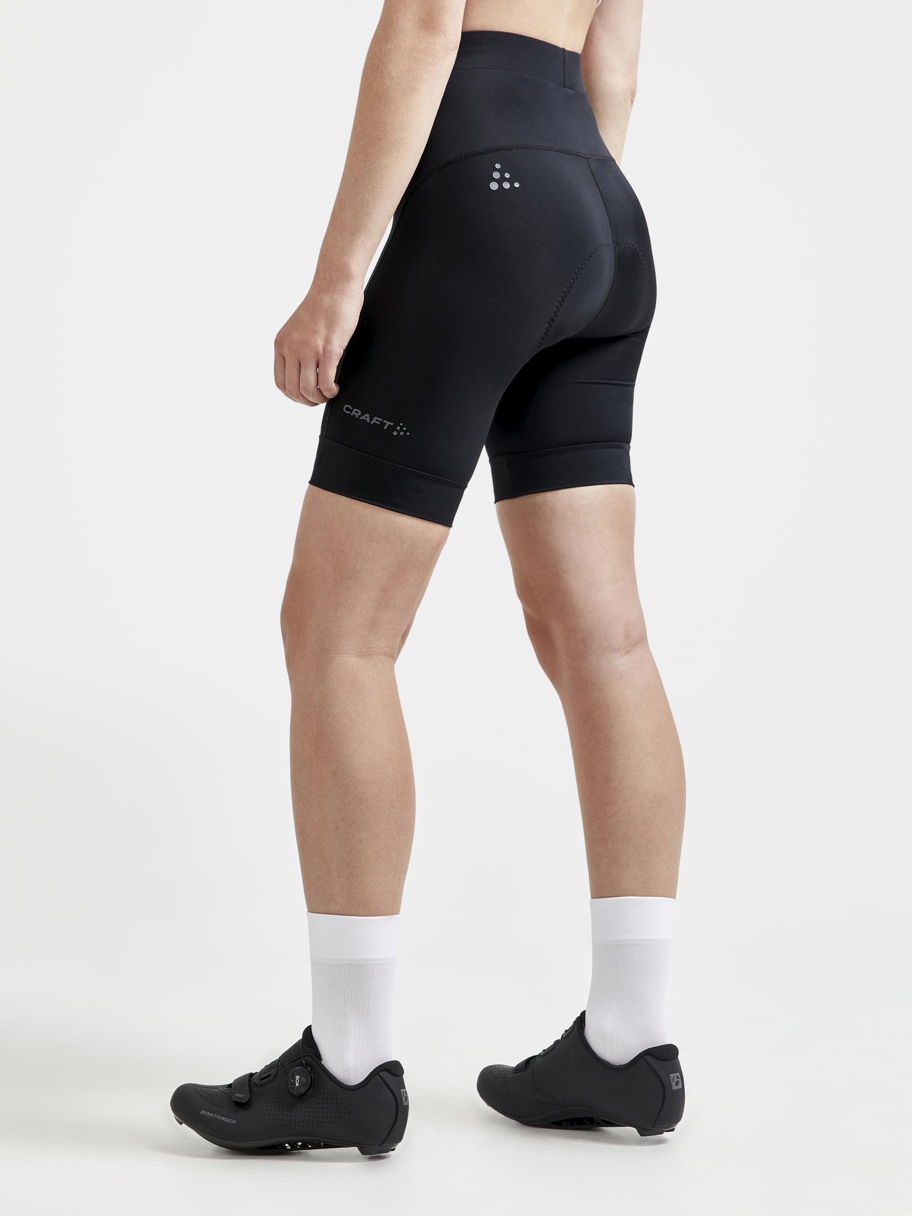 Woman models black cycling shorts with padded seat from the back.