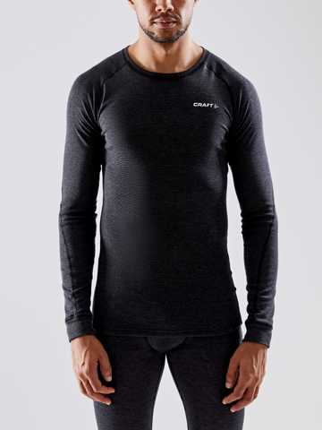 Man models a Craft brand charcoal grey merino wool base layer long sleeve shirt and pants.