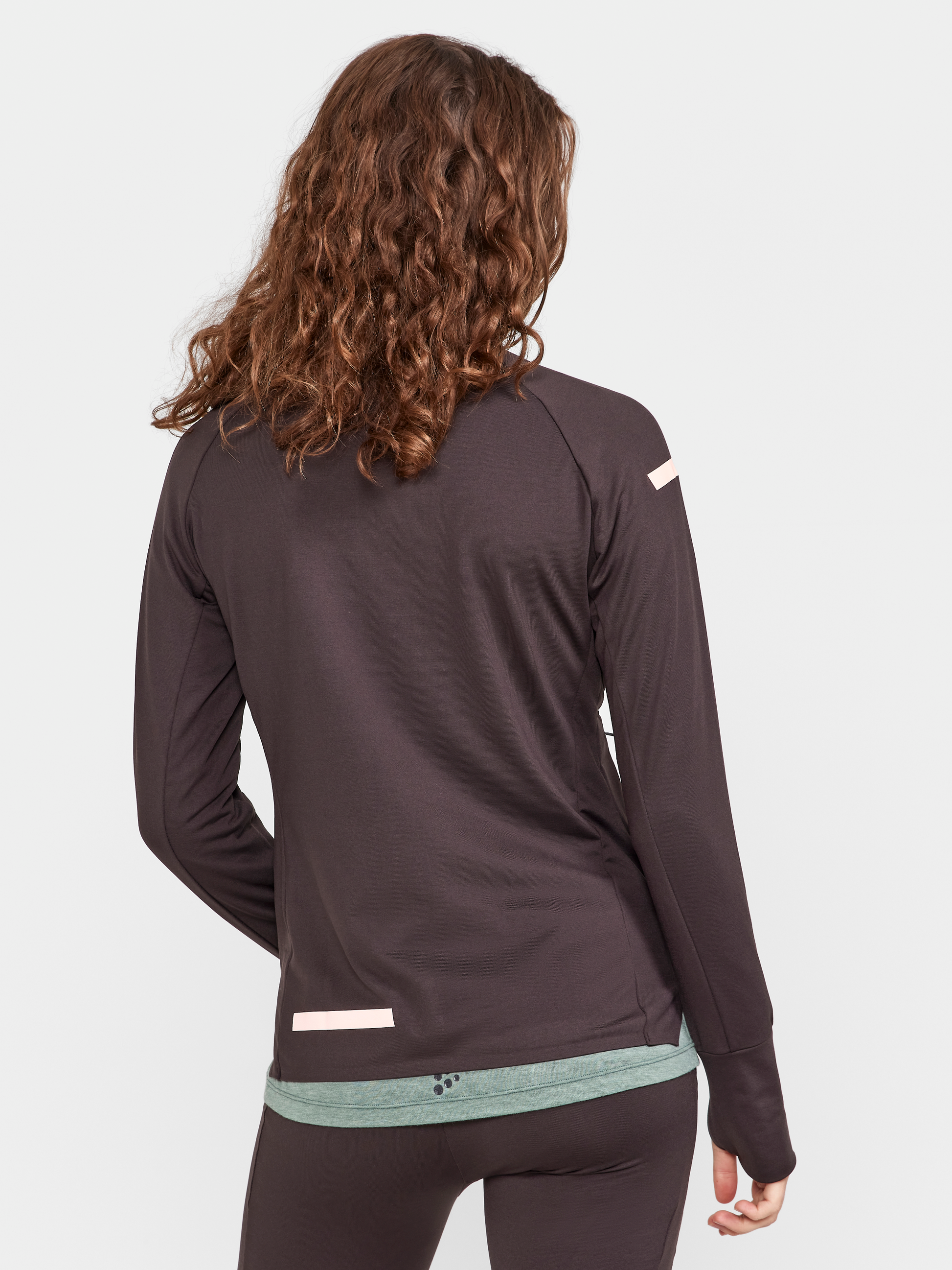 Woman models a dark gray athletic half-zip pullover from the back.