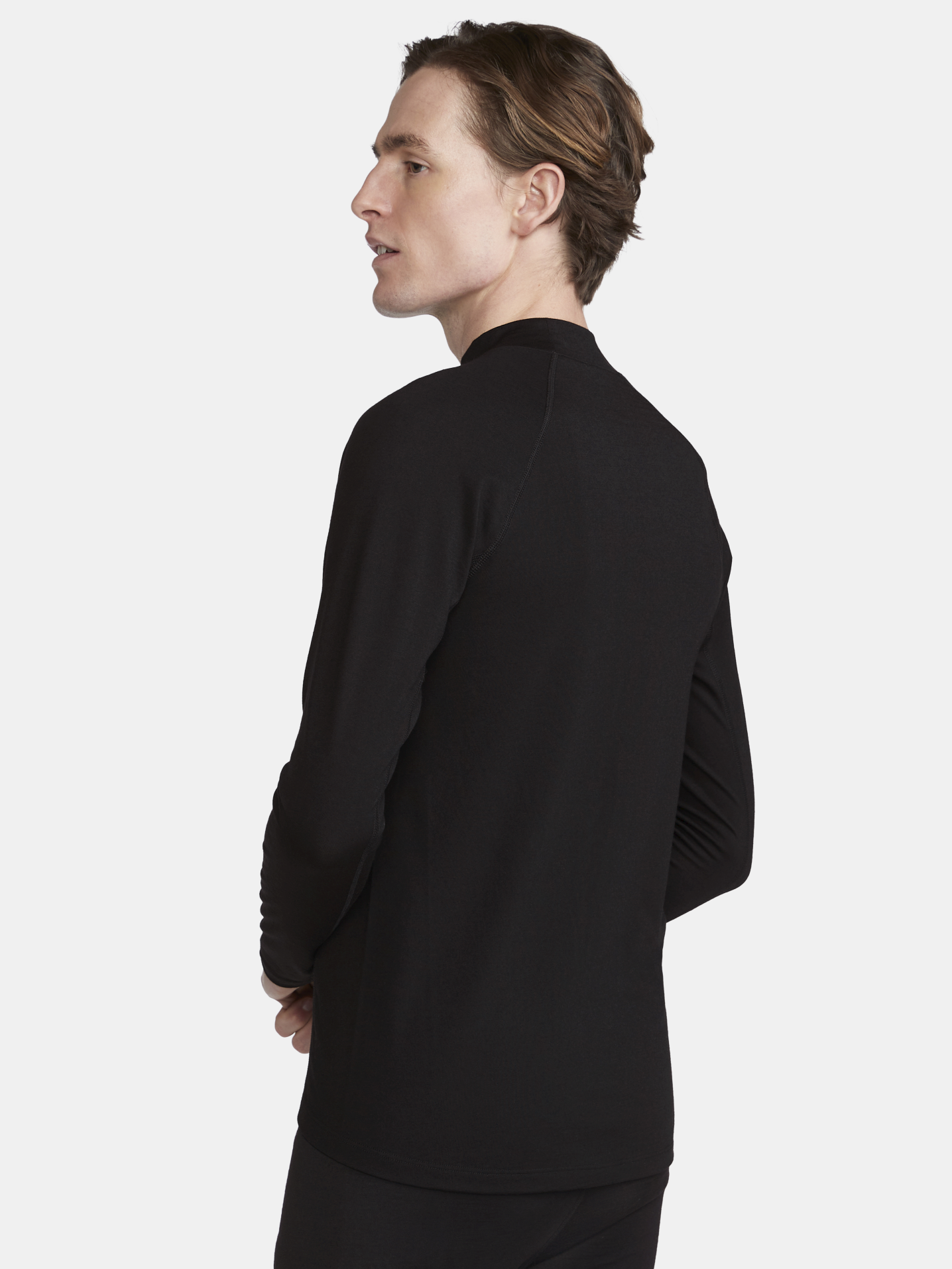 Man models a black long-sleeve base layer shirt.
