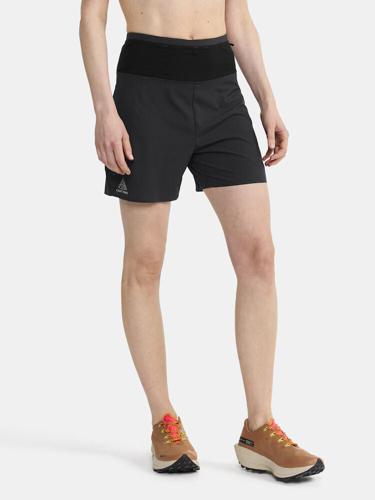 Woman models black athletic shorts with built-in liner, standing against a white background.
