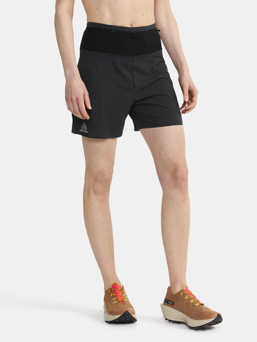 Woman models black athletic shorts with built-in liner, standing against a white background.