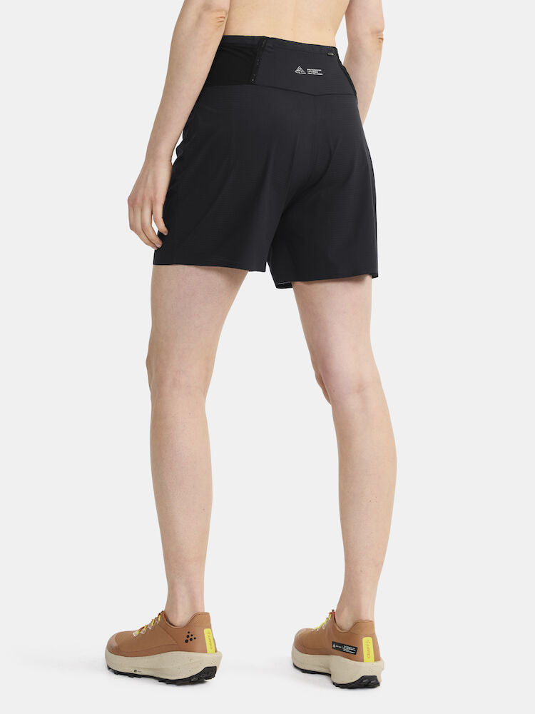 Woman models black running shorts with back pockets from the rear.