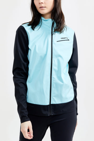 Woman models a light blue and black Craft brand lightweight running jacket.