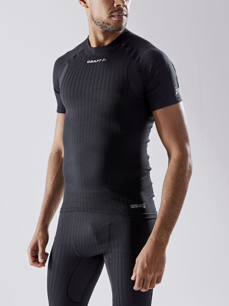 Man models a black Craft Coolmax base layer, short sleeve, crew neck top with matching leggings.