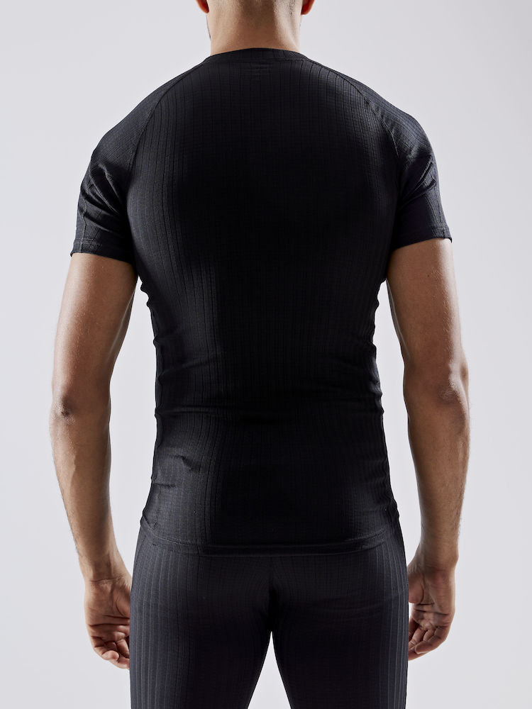 Man models black thermal compression shirt, showcasing the back view.