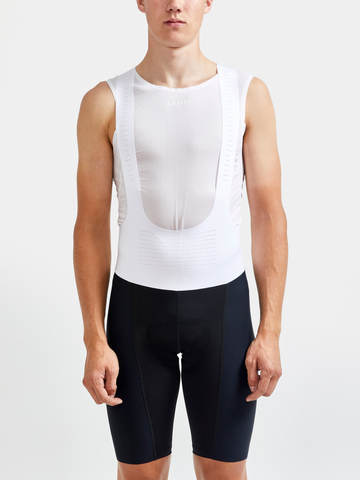 Man models black cycling bib shorts and a white sleeveless base layer.
