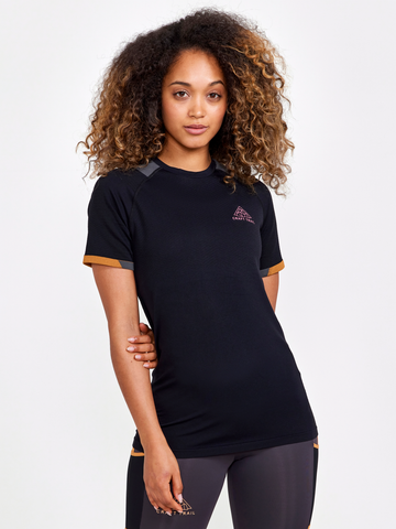 Woman models a black athletic t-shirt with orange trim and the Craft Trail logo. 
