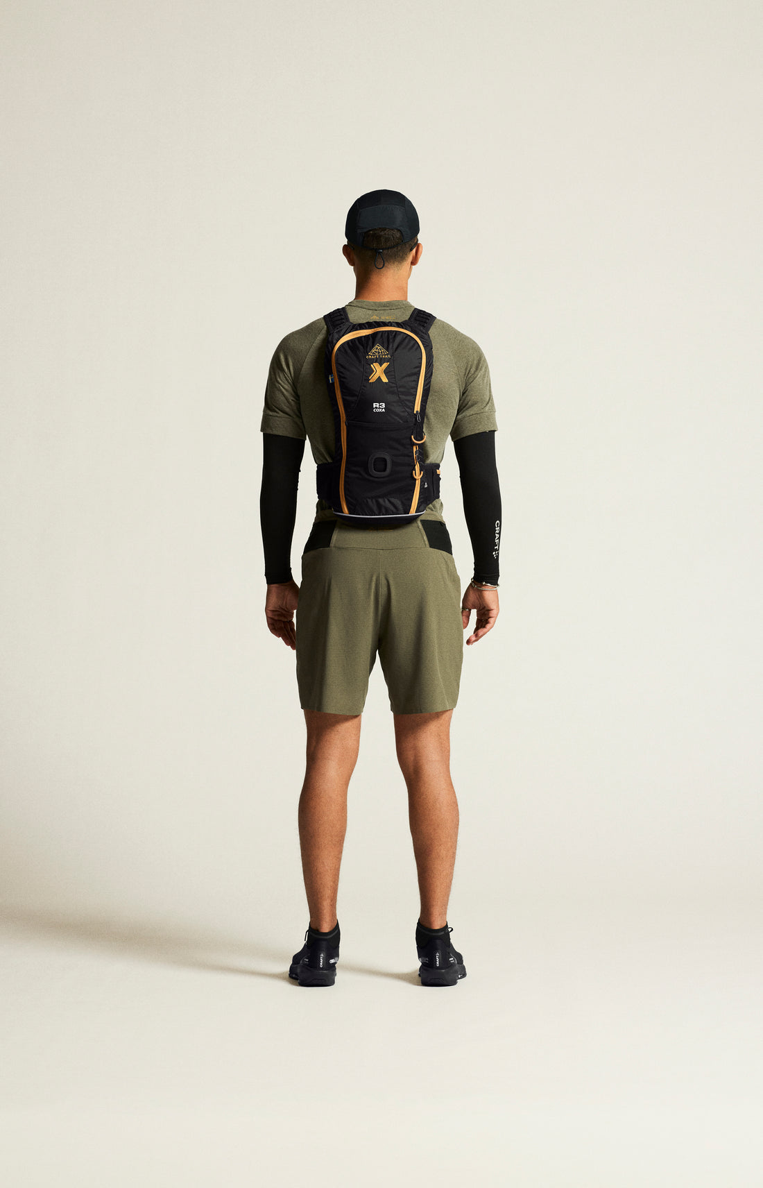 Man models olive green running shorts and black compression sleeves. 
