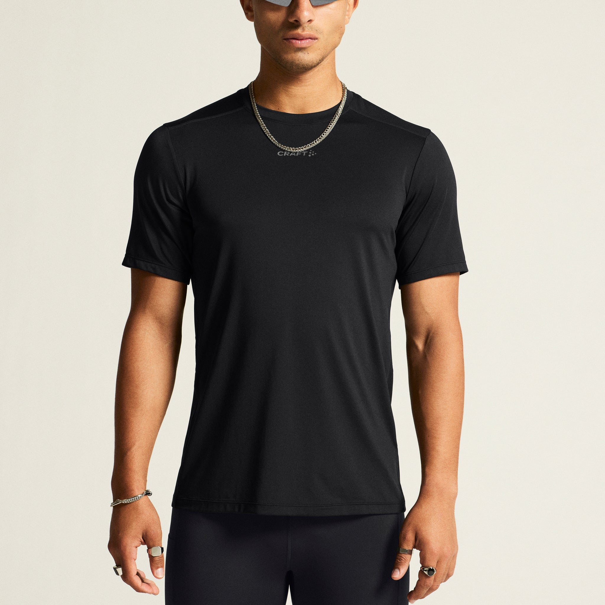 Man models a black athletic t-shirt and black running tights. 
