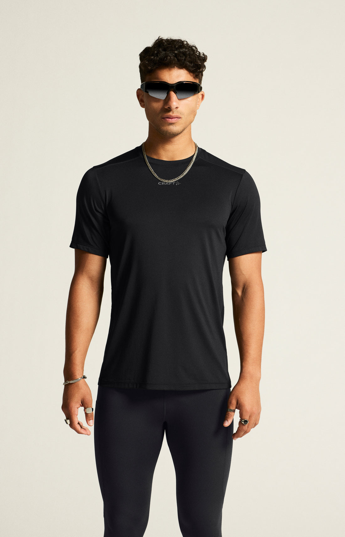Man models a black athletic t-shirt and black running tights. 
