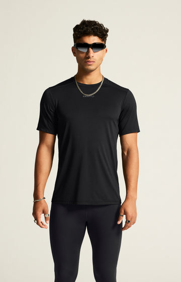 Man models a black athletic t-shirt and black running tights. 
