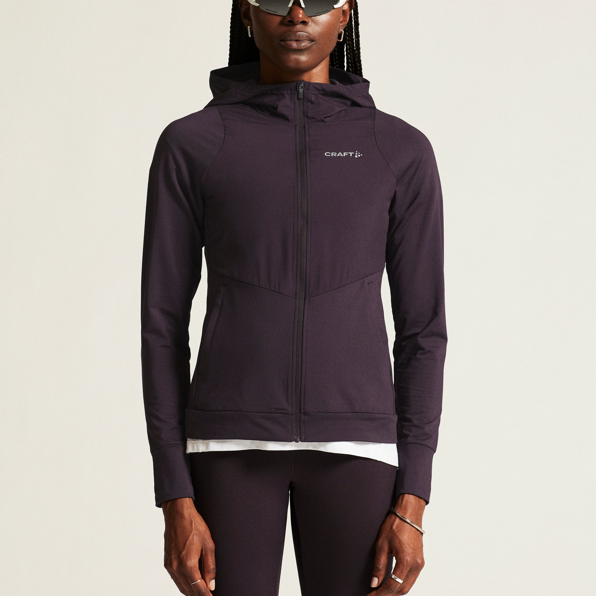 Woman models a plum-colored athletic hoodie with a full-zip front and hood. 
