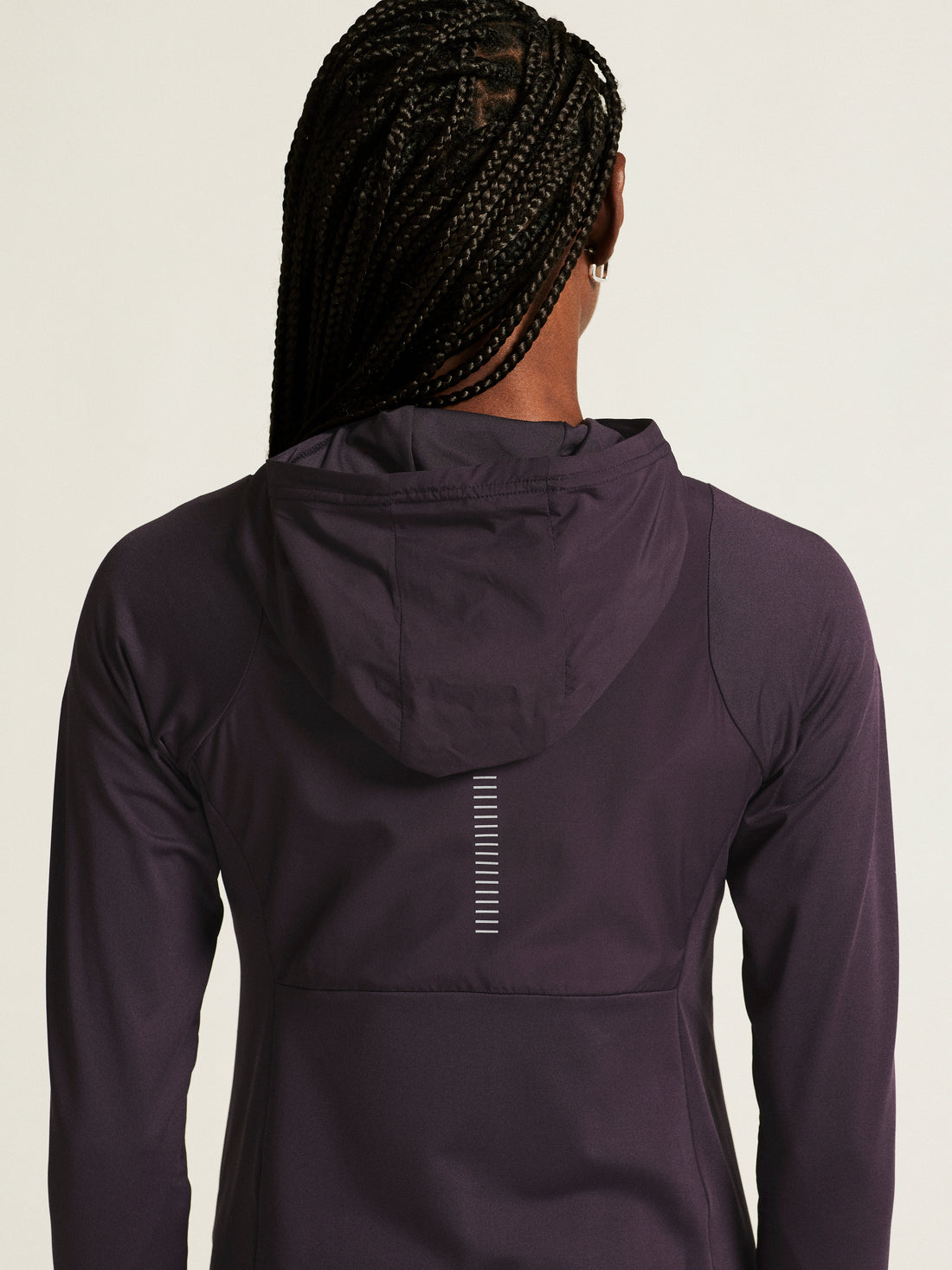 Woman models a plum-colored athletic hoodie with a full-zip front and hood. 
